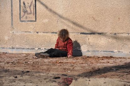 Una niña siria, en el suelo, a la intemperie, en pleno invierno.