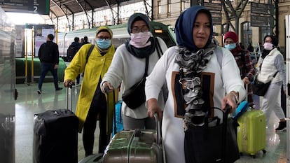 Tourists with face masks arrive at the train station in Valencia.