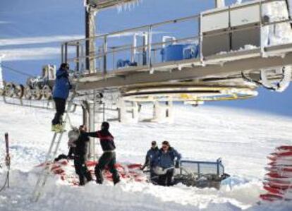 Operarios de la estación invernal de Sierra Nevada en Granada limpian los remonte mecánicos. EFE/Archivo