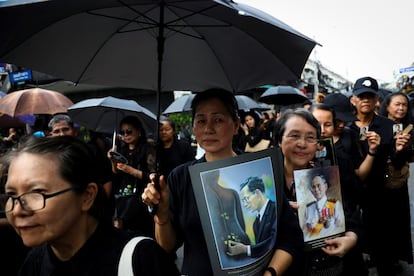 Miles de tailandeses vestidos de negro y con imagenes del rey Bhumibol.