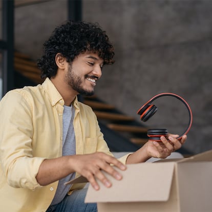 Un hombre sacando unos auriculares de una caja.