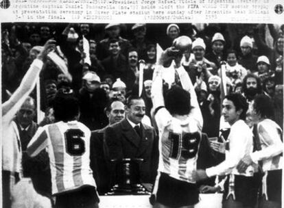 Daniel Passarella levanta el trofeo ante Havelange, a la izquierda, entre dos jugadores, y el presidente de la Junta Militar argentina, Jorge Rafael Videla, en el medio.