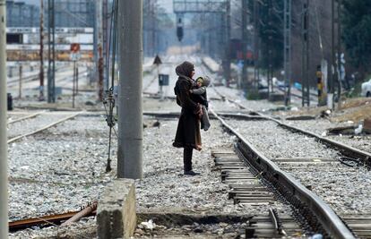 Una refugiada con su hijo esperan para cruzar la frontera entre Grecia y Macedonia, cerca de Gevgelija.