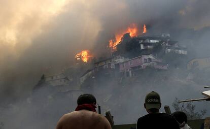 Vários homens contemplam o incêndio na serra Rocuant, de Valparaíso, na noite de terça-feira.