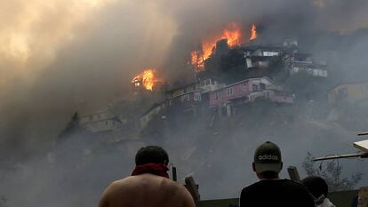 Vários homens contemplam o incêndio na serra Rocuant, de Valparaíso, na noite de terça-feira.