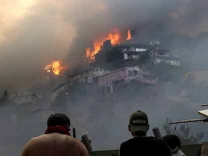 Vários homens contemplam o incêndio na serra Rocuant, de Valparaíso, na noite de terça-feira.