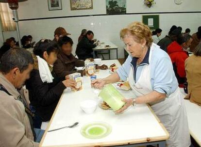 Una voluntaria atiende a los comensales del primer comedor municipal para parados, creado en Móstoles.