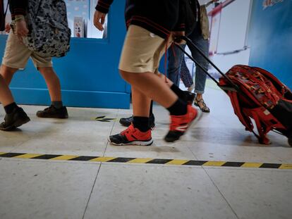 Varios niños entran a sus aulas en el primer día de colegío.