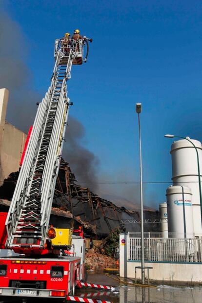 Los bomberos trabajando en el control del incendio que se ha declarado en una planta de recicleja de Sant Adrià del Besòs (Barcelona).