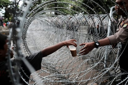 Un policía indonesio compra una bebida mientras se encuentra de guardia en un tribunal de Yakarta (Indonesia), el 10 de enero.