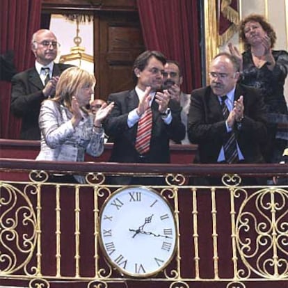 Los representantes del Parlamento catalán aplauden tras la votación que admitió a trámite la reforma del Estatuto con la única oposición del PP.