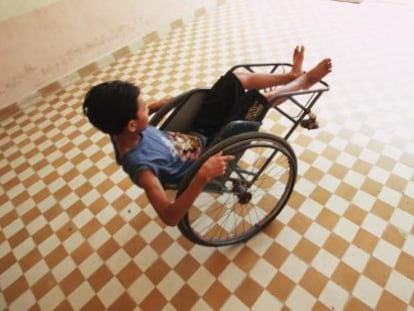 Uma criança com deficiência brinca com sua cadeira de rodas.