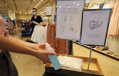 Una mujer usa gel hidroalcohólico antes de entrar a una tienda de ropa en Las Palmas, este lunes.