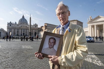 La víctima y activista Phil Saviano, cono un retrato suyo a la edad en la que sufrió abusos, en la plaza de San Pedro.