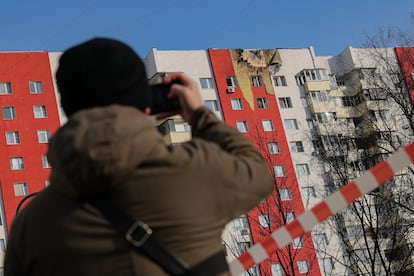 Un hombre fotografía los daños en un edificio por un dron ucranio, en Moscú.