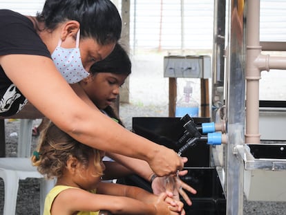 Crianças lavam as mãos em Roraima, no norte de Brasil.