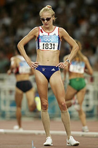 Paula Radcliffe, mira al suelo, desconsolada, tras retirarse de la prueba.