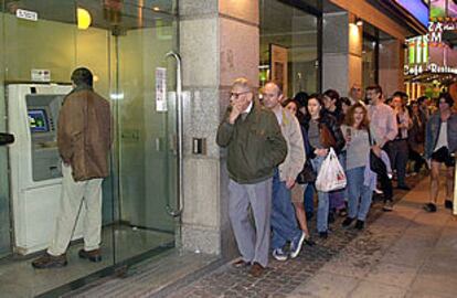 Clientes del Banco Nazionale del Lavoro esperan su turno ante un cajero el pasado fin de semana en Buenos Aires.