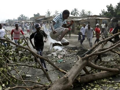 Un hombre salta una barricada durante una protesta en la ciudad de Bujumbura (Burundi)