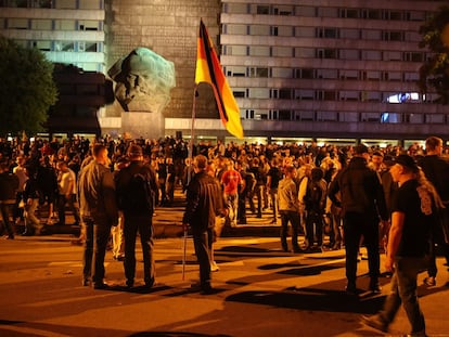 Manifestantes de ultraderecha finalizan una concentración xenófoba, junto a un monumento de Karl Marx, en Chemnitz (Alemania).