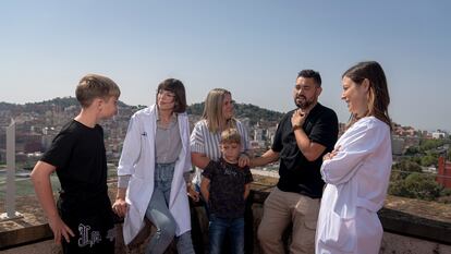 Hematologist Julia Montoro (right), head of the Hematology Genetic Counseling Unit at Vall d'Hebron, and geneticist Sara Torres Esquius, chat with one of their patients, Elisabeth Carabante, and her family, on the hospital's rooftop in Barcelona.