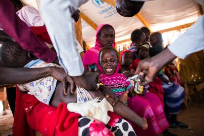 Un enfermero de la Organización Mundial de la Salud vacuna a un niño refugiado sudanés recién trasladado al campamento de Ajuong Thok. No solo la seguridad mueve a decenas de miles de sudaneses a cruzar la frontera, sino también para acogerse a los servicios que se les ofrecen por su condición de refugiados: atención sanitaria, comida, alojamiento y educación, entre otros.