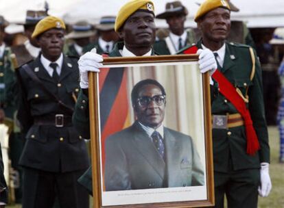 Un soldado del Ejército de Zimbabue sujeta un retrato de Robert Mugabe, presidente del país.