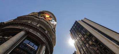 Banderas de la UE, España, Comunidad Valenciana y Caixa ondeando en los balcones de la sede de Caixabank, en Valencia