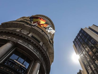 Banderas de la UE, España, Comunidad Valenciana y Caixa ondeando en los balcones de la sede de Caixabank, en Valencia