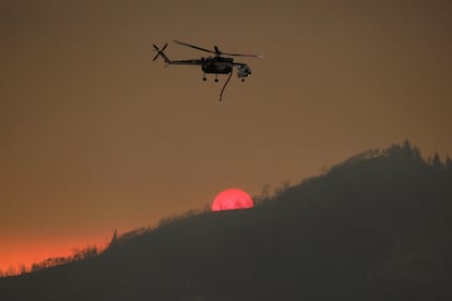 Un helicóptero sobrevuela la zona afectada por el fuego.