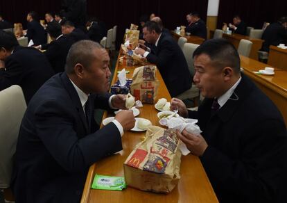 Miembros de las delegaciones participantes comen hamburguesas y empanadillas chinas, mientras el presidente Obama y el presidente Jinping cenan en privado en el complejo que acogió la cumbre, tras la clausura de la misma.