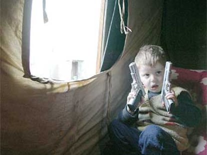 Un niño juega en el interior de una tienda de campaña en el campo de refugiados chechenos de Karabulak, en Rusia.