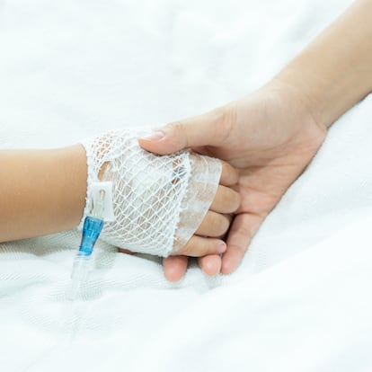 Young Asian girl hand of a patient with medical drip or IV drip in hospital ward, Selective focus.