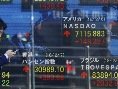Un peat&oacute;n camina frente a una pantalla que muestra indicadores financieros este mi&eacute;rcoles 7 de febrero de 2018, en Tokio (Jap&oacute;n). 