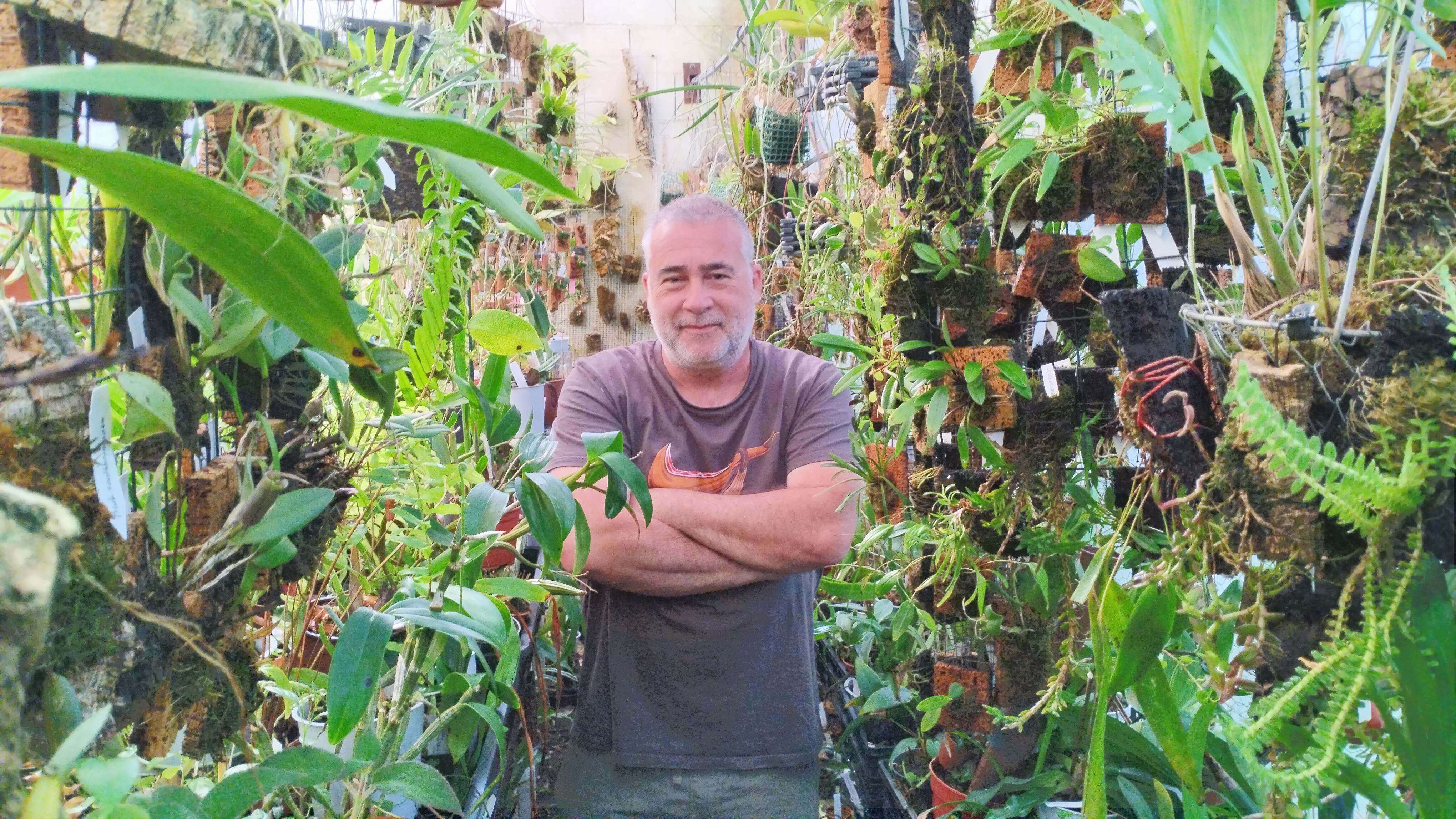 Rubén Velázquez rodeado de las orquídeas que cultiva.