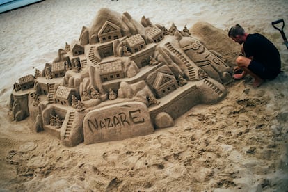 Un joven construye un castillo de arena en la playa de Nazaré, el arenal más tranquilo del pueblo portugués.

