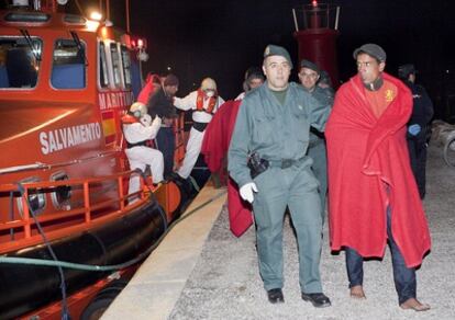 Agentes de la Guardia Civil ayudan esta madrugada a desembarcar a 31 inmigrantes de origen marroquí en el puerto granadino de Motril.