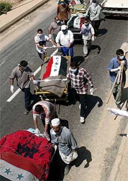 Residentes en Bagdad portan en camillas cadáveres sin identificar.
