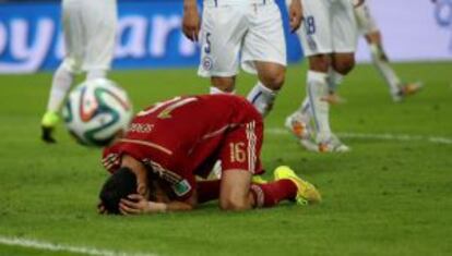 Busquets se lamenta en el partido que apeó a España del Mundial de Brasil.