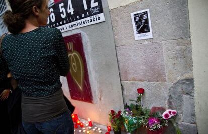 Una mujer mira la foto de Benítez, frente a su casa.