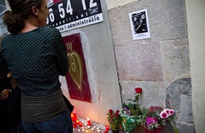 Una mujer mira la foto de Ben&iacute;tez, frente a su casa.