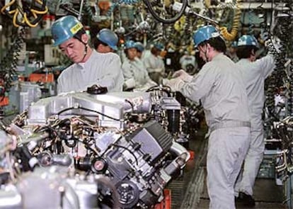 Trabajadores ensamblando motores en la planta de Mitsubishi Motors de Kawasaki