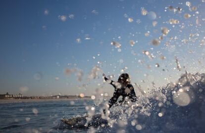 EPA7145. CIUDAD DEL CABO (SUDÁFRICA), 25/10/2018.- Una surfista monta una ola al amanecer en una playa de Ciudad del Cabo (Sudáfrica), el 25 de octubre de 2018. La playa de Surfers Corner, cuna de este deporte en Sudáfrica hace ya más de 100 años, es la playa de referencia para los que se inician en el surf por sus olas sencillas y de largo recorrido, ya que pueden extenderse hasta unos cien metros.