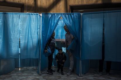 Una mujer, acompañada de sus hijos, ejerce su derecho al voto en Kiev (Ucrania).