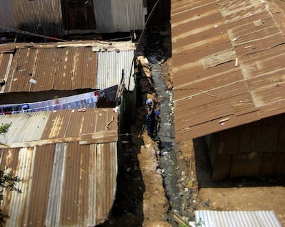 Una residente del suburbio de Kibera (Nairobi) se lava los dientes junto a una zanja donde se acumulan basura y aguas negras.