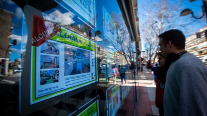 Jóvenes ante anuncios de una inmobiliaria de Madrid.