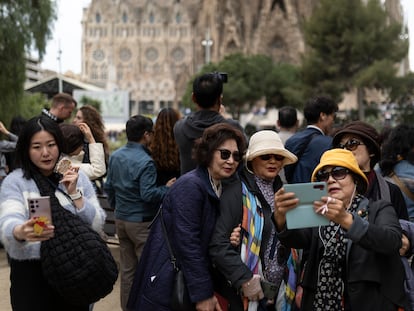 Turistas asiáticas posan frente a la Sagrada Familia en Barcelona