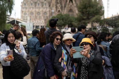 Turistas asiáticas posan frente a la Sagrada Familia en Barcelona