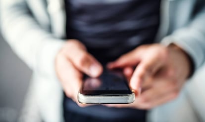 Un joven utiliza un teléfono móvil.