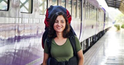 Una joven mochilera camina en una estación de tren.